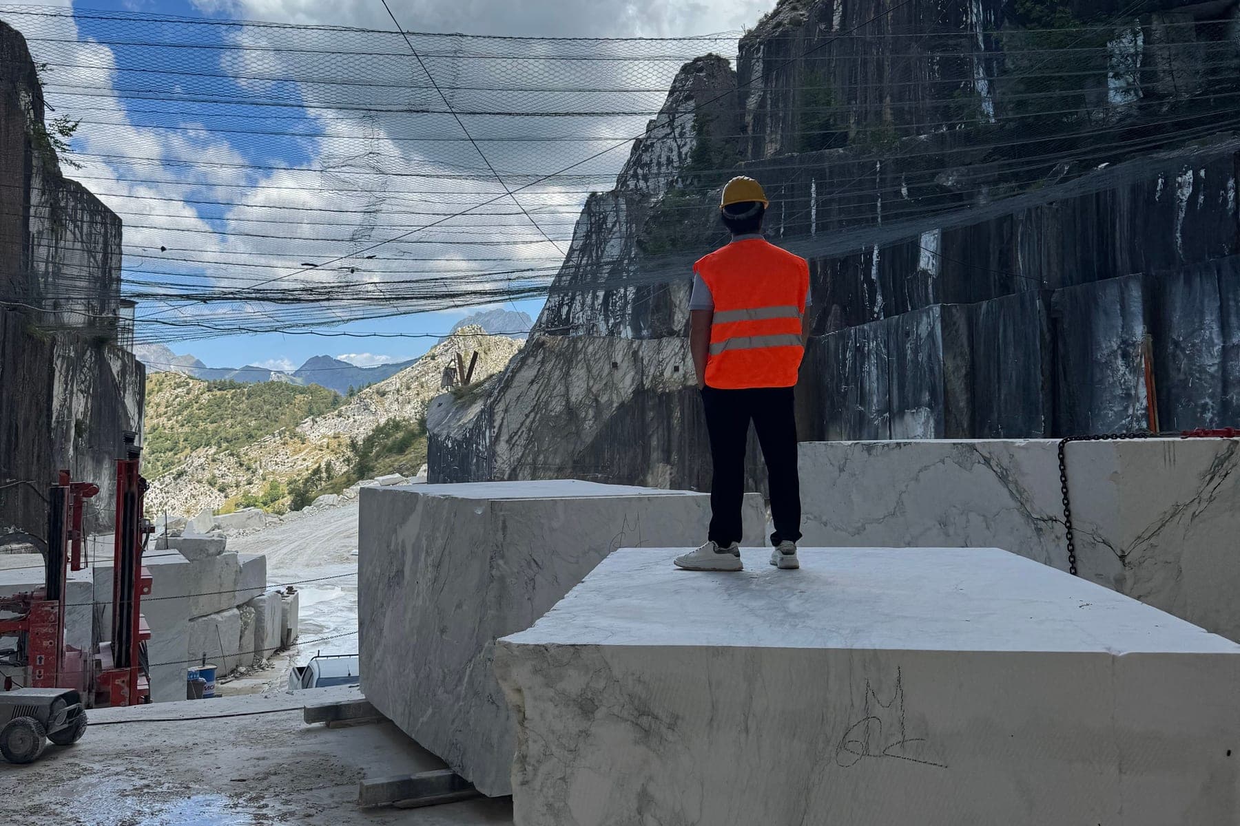 Standing on a cut marble block in the quarry, looking out over the valley